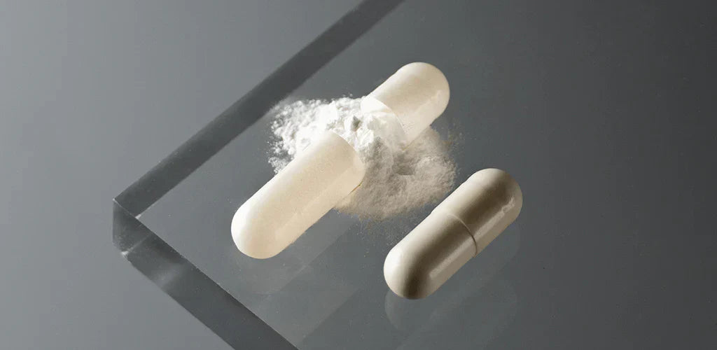 Gélules et poudre de magnésium pour illustrer la différence entre citrate de magnésium et bisglycinate de magnésium