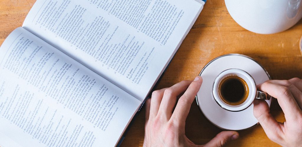 Livre ouvert et tasse de café pour illustrer comment choisir des compléments pour la concentration