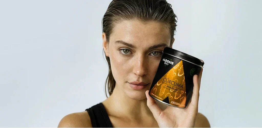 Femme tenant un complément au curcuma Aldous Bio pour illustrer les meilleurs compléments alimentaires pour l’été